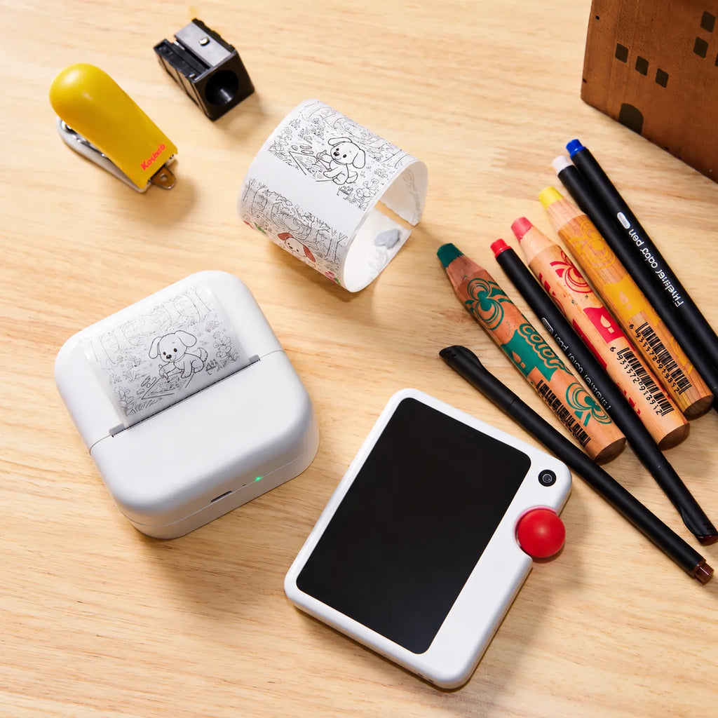 GigglePal Pocket and a mini printer beside printed dog drawings and coloring supplies.